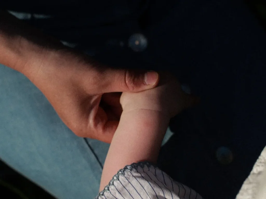 Parent holding a child’s hand as a symbol of care and protection