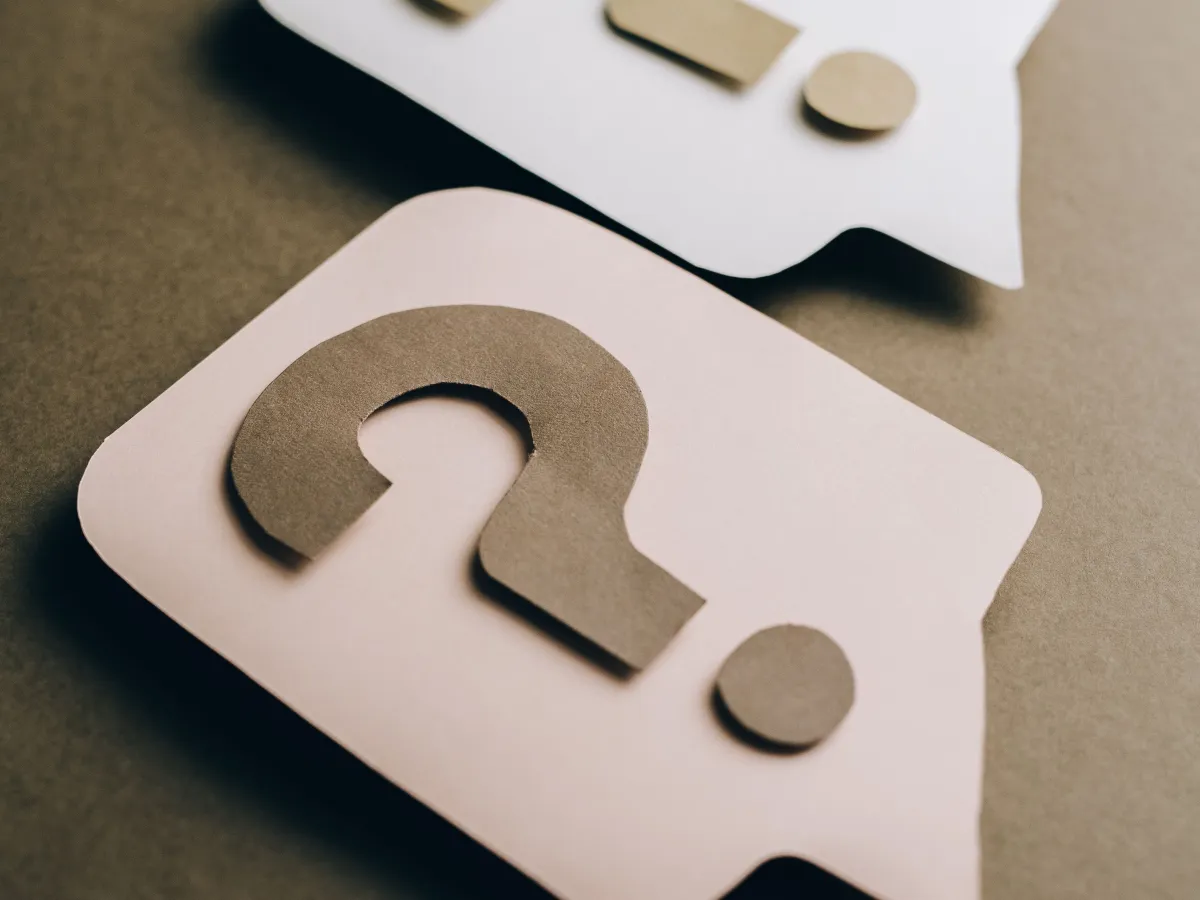 Paper question marks and speech bubbles representing FAQ navigation
